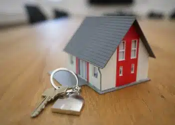 white and red wooden house miniature on brown table